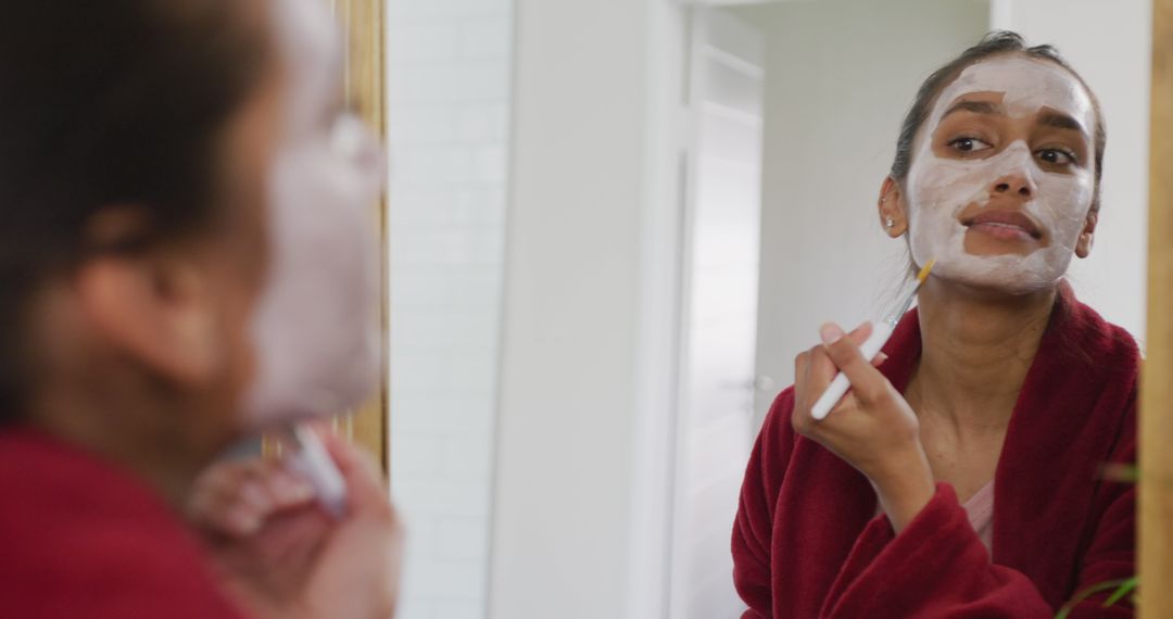 Woman Applying Facial Mask and Looking in Mirror - Free Images, Stock Photos and Pictures on Pikwizard.com