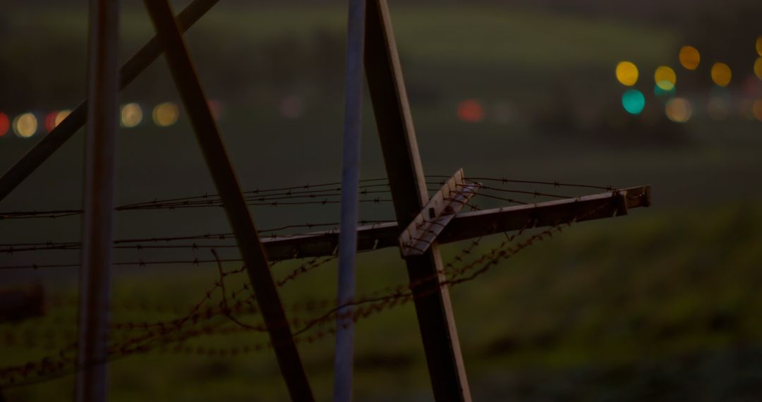 Barbed Wire Fence Overlooking Blurred Night City Lights - Free Images, Stock Photos and Pictures on Pikwizard.com