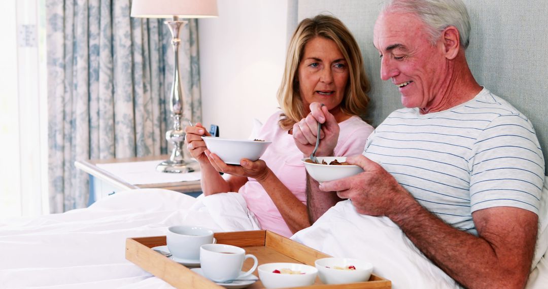 Senior Couple Enjoying Breakfast in Bed with Coffee and Cereal - Free Images, Stock Photos and Pictures on Pikwizard.com