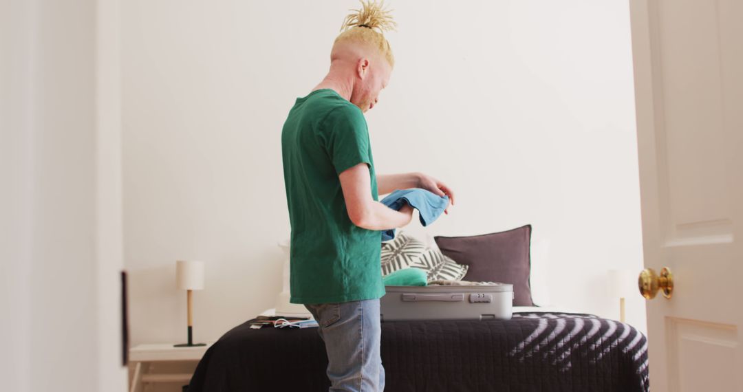 Man Packing Clothes in Suitcase in Bright Modern Bedroom - Free Images, Stock Photos and Pictures on Pikwizard.com