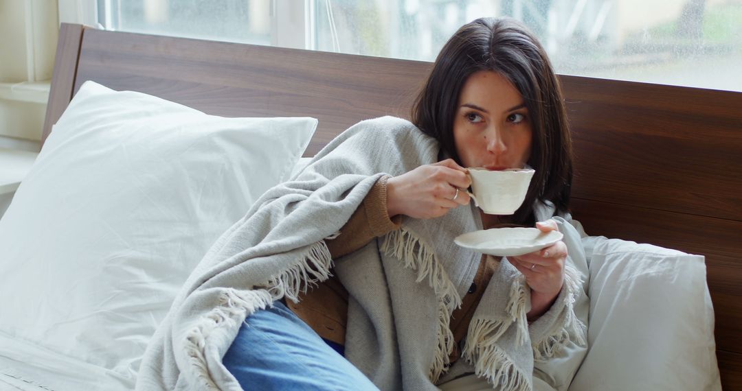 Woman Relaxing in Bed While Drinking Tea on a Cozy Morning - Free Images, Stock Photos and Pictures on Pikwizard.com