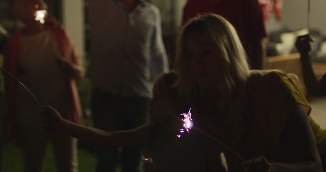 Mother and Daughter Holding Sparkler at Nighttime Celebration - Free Images, Stock Photos and Pictures on Pikwizard.com