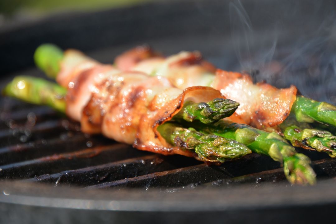 Bacon-Wrapped Asparagus Grilling on Charcoal Grill with Smoky Char Marks