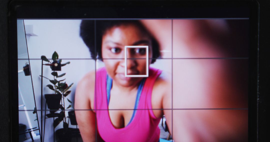 African American woman taking selfie in pink top through camera viewfinder - Free Images, Stock Photos and Pictures on Pikwizard.com