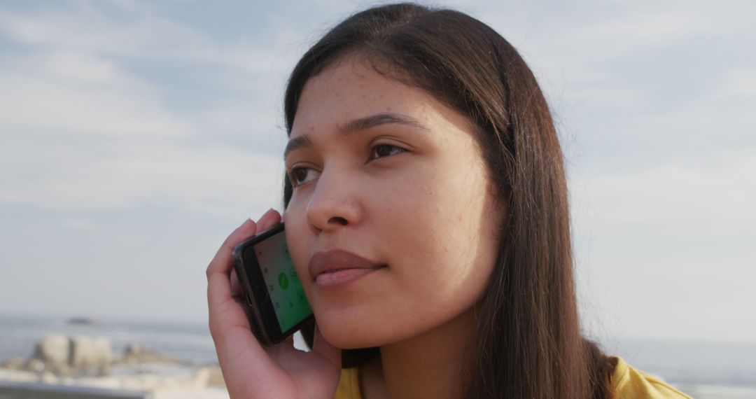 Young Woman Talking on Smartphone Outdoors near Beach - Free Images, Stock Photos and Pictures on Pikwizard.com