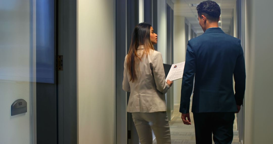 Two Business Professionals Conversing in Office Hallway