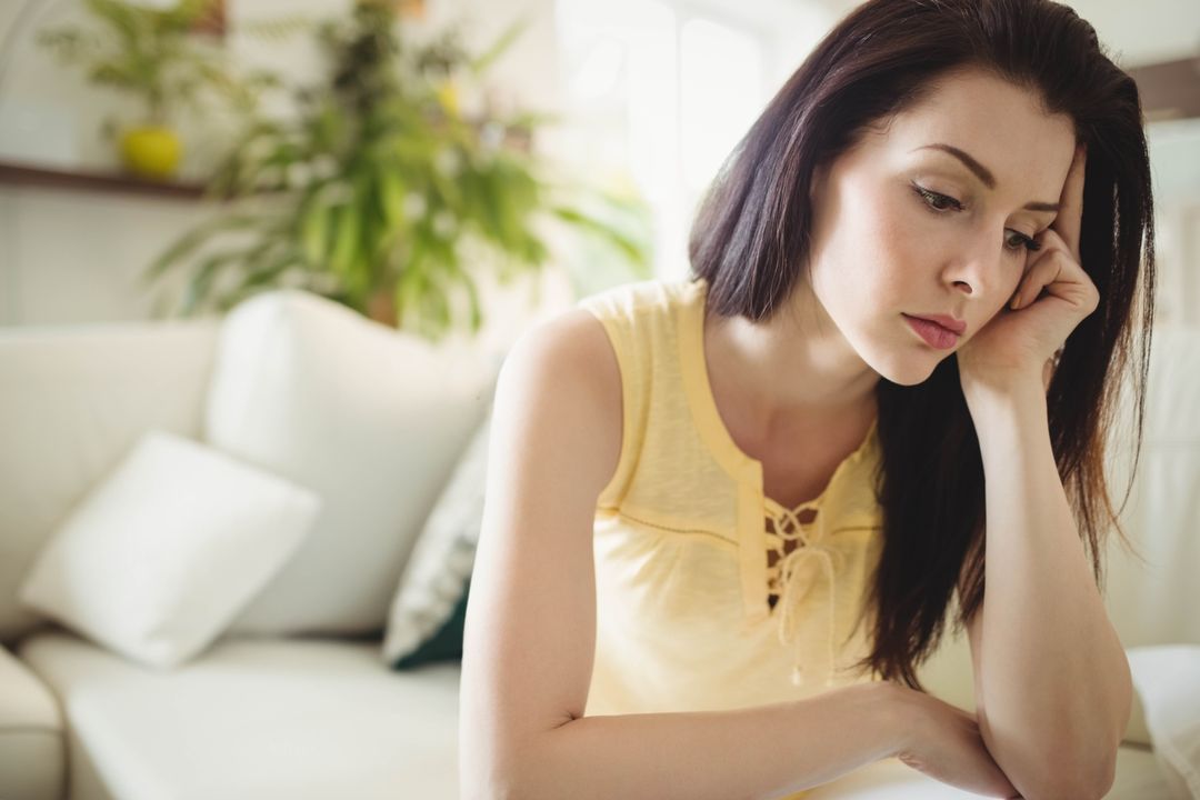 Thoughtful Woman Relaxing at Home in Cozy Living Room