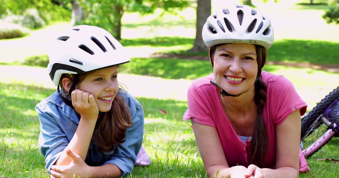 Mother and Daughter Relaxing in Park with Bicycle Helmets - Free Images, Stock Photos and Pictures on Pikwizard.com