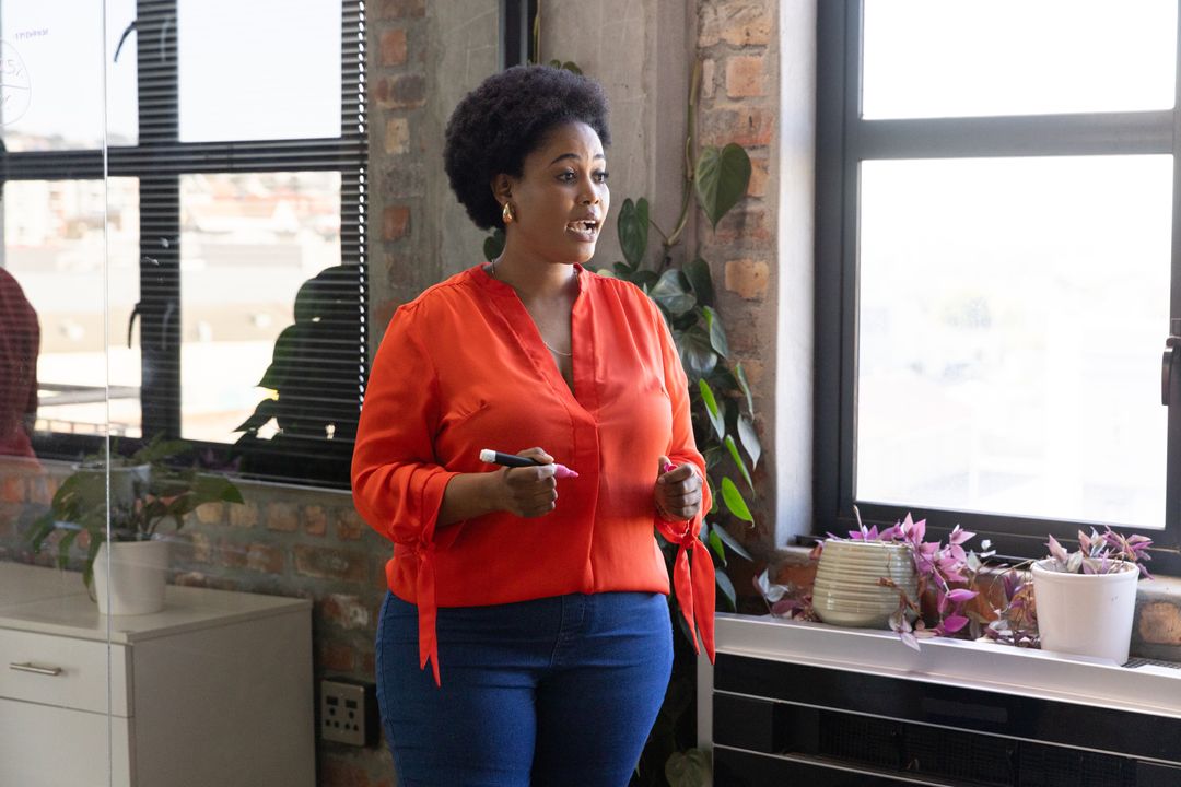 Professional Woman in Red Blouse Holding Meeting at Office Partition