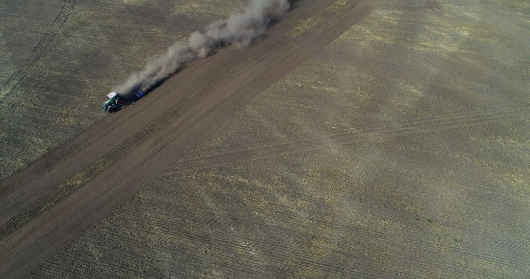 Aerial View of Tractor Plowing Dry Farmland with Dust Trail - Free Images, Stock Photos and Pictures on Pikwizard.com