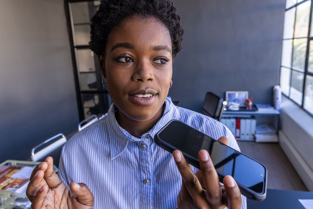 Professional Woman Discussing Business via Smartphone in Modern Office