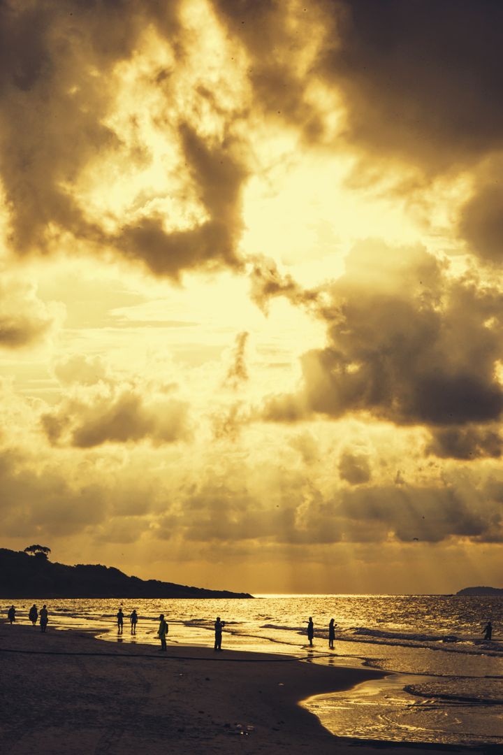 Dramatic Sunset Beach with Silhouetted People - Free Images, Stock Photos and Pictures on Pikwizard.com