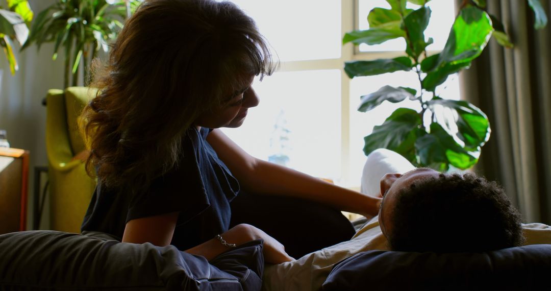 Woman Comforting Partner in Living Room with Lush Green Plants - Free Images, Stock Photos and Pictures on Pikwizard.com