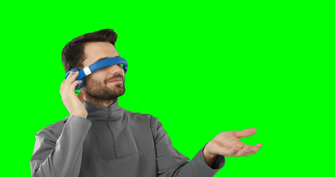 Man Experiencing Virtual Reality with VR Headset and Gesture in Green Screen Studio - Free Images, Stock Photos and Pictures on Pikwizard.com