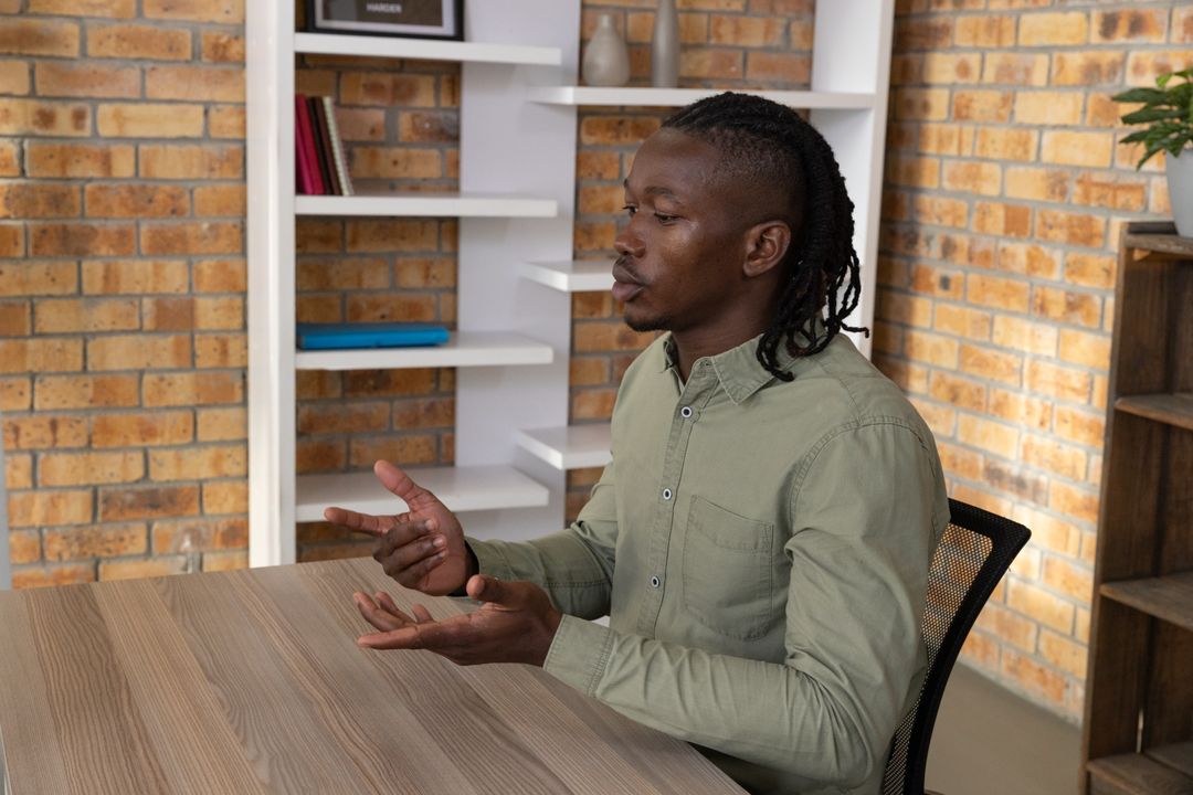 Professional African American Man Engaging in Conversation at Desk