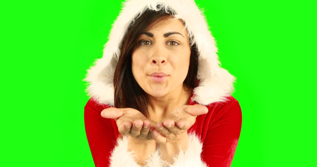 Brunette Woman in Santa Outfit Blowing Kiss on Green Background - Free Images, Stock Photos and Pictures on Pikwizard.com