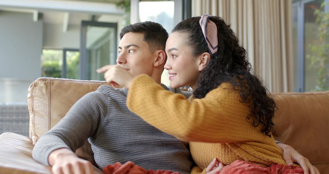 Diverse Couple Relaxing on Sofa near Open Glass Door