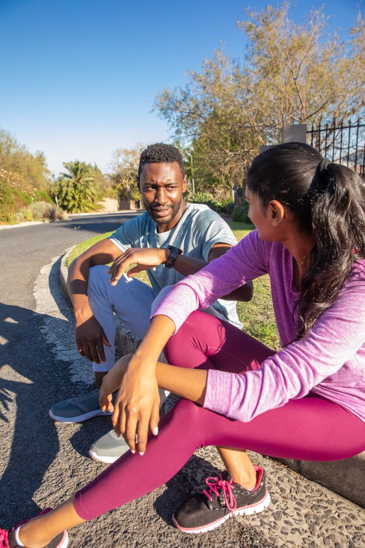 Diverse Friends Relaxing After Run on Suburban Street