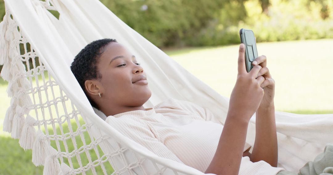 Young Person Relaxing in Hammock Using Smartphone Outdoors - Free Images, Stock Photos and Pictures on Pikwizard.com