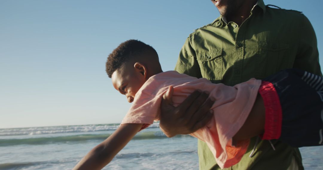 Father Holding Son Enjoying Playtime at Beach Sunset - Free Images, Stock Photos and Pictures on Pikwizard.com