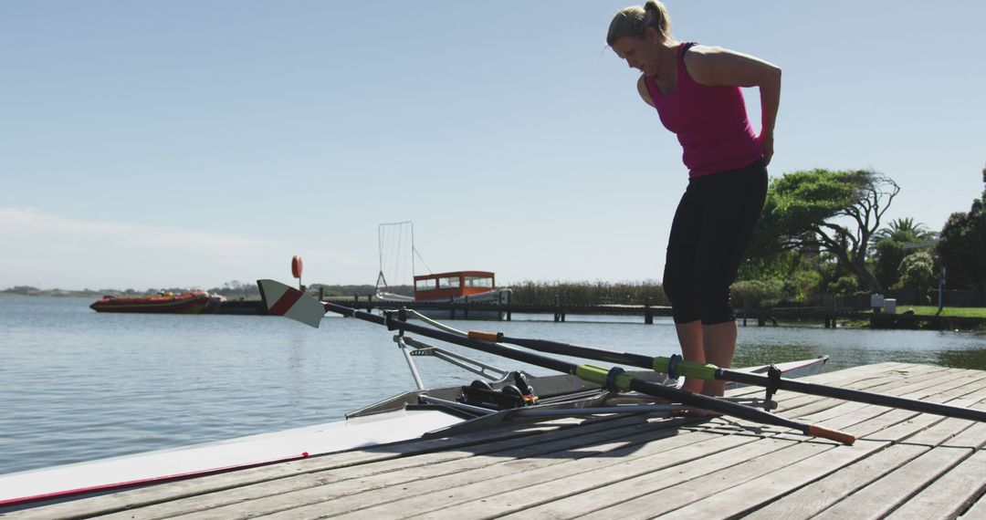 Female Rower Preparing Boat on Tranquil Lake Pier - Free Images, Stock Photos and Pictures on Pikwizard.com