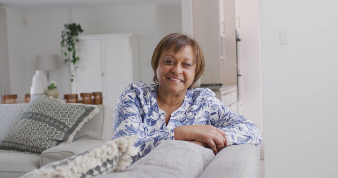 Senior Woman Smiling While Relaxing on Comfortable Sofa - Free Images, Stock Photos and Pictures on Pikwizard.com