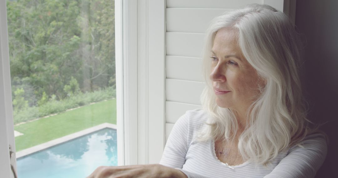 Pensive Older Woman with Grey Hair Looking out Window - Free Images, Stock Photos and Pictures on Pikwizard.com