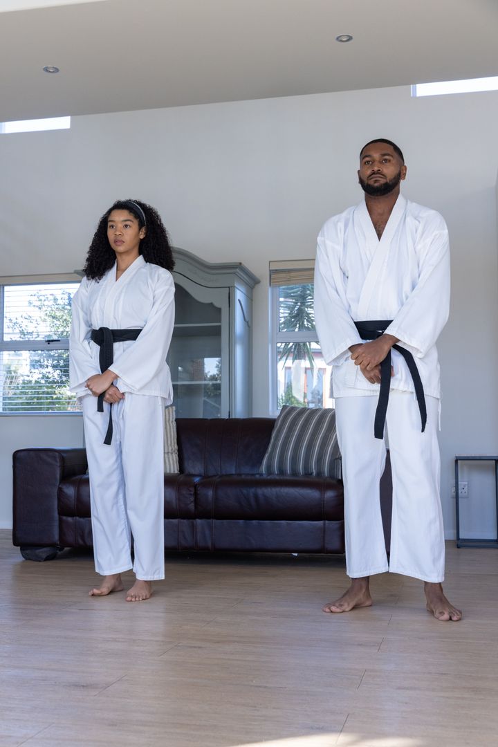 Martial Artists Practicing Stance at Home in Traditional Gis