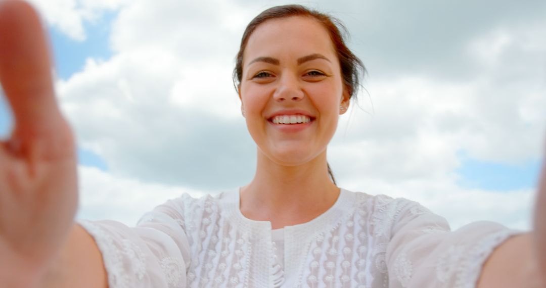 Happy Woman Smiling while Taking Selfie Outdoors with Clouds in Background - Free Images, Stock Photos and Pictures on Pikwizard.com