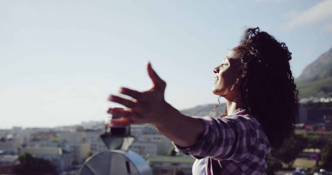 Young Woman Embracing Freedom on Rooftop with Open Arms - Free Images, Stock Photos and Pictures on Pikwizard.com