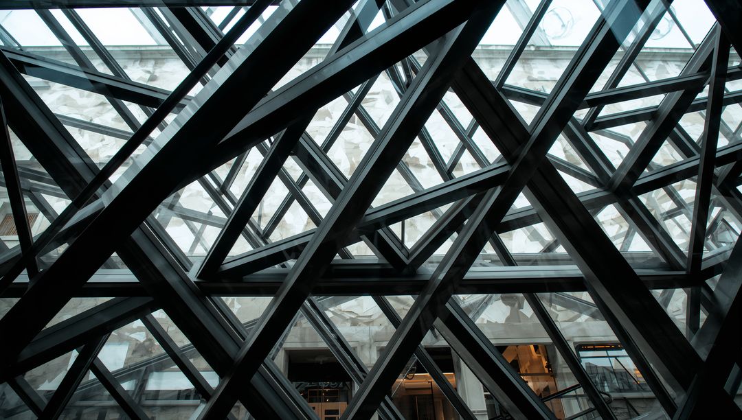 Intersecting Steel and Glass Beams Creating Complex Geometric Canopy over Urban Atrium