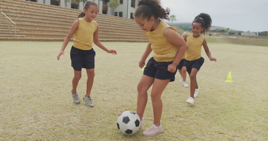 Image of happy diverse girls playing soccer in front of school - Free Images, Stock Photos and Pictures on Pikwizard.com