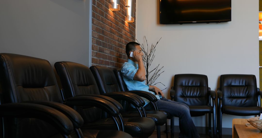 Man sitting in modern waiting room calling on phone - Free Images, Stock Photos and Pictures on Pikwizard.com