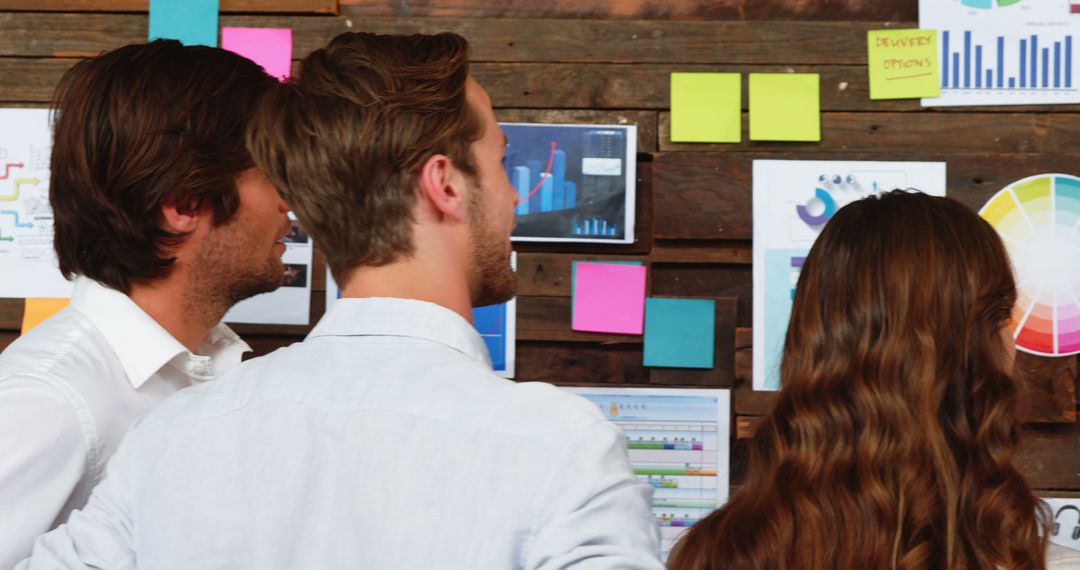 Team Analyzing Business Strategies with Charts and Notes