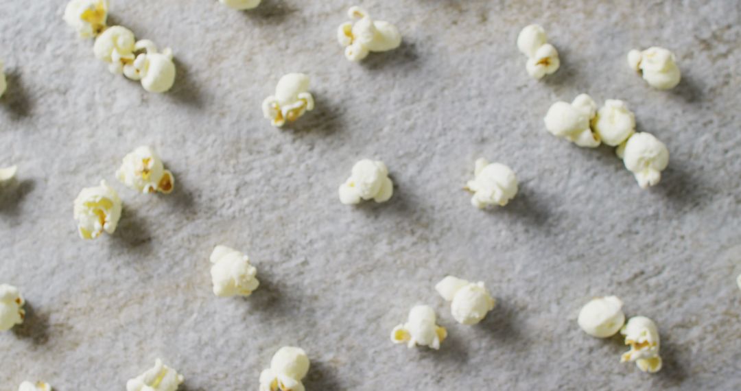 Close-Up Shot of Scattered Popcorn on Gray Surface