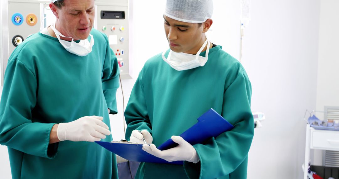 Surgeons Discussing Patient Information in Operating Room - Free Images, Stock Photos and Pictures on Pikwizard.com