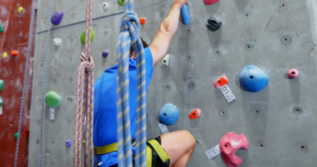 Caucasian Man Climbing Indoor Wall with Colorful Holds - Free Images, Stock Photos and Pictures on Pikwizard.com