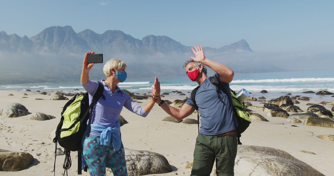 Senior Couple Enjoying Beach Hike Video Call with Masks