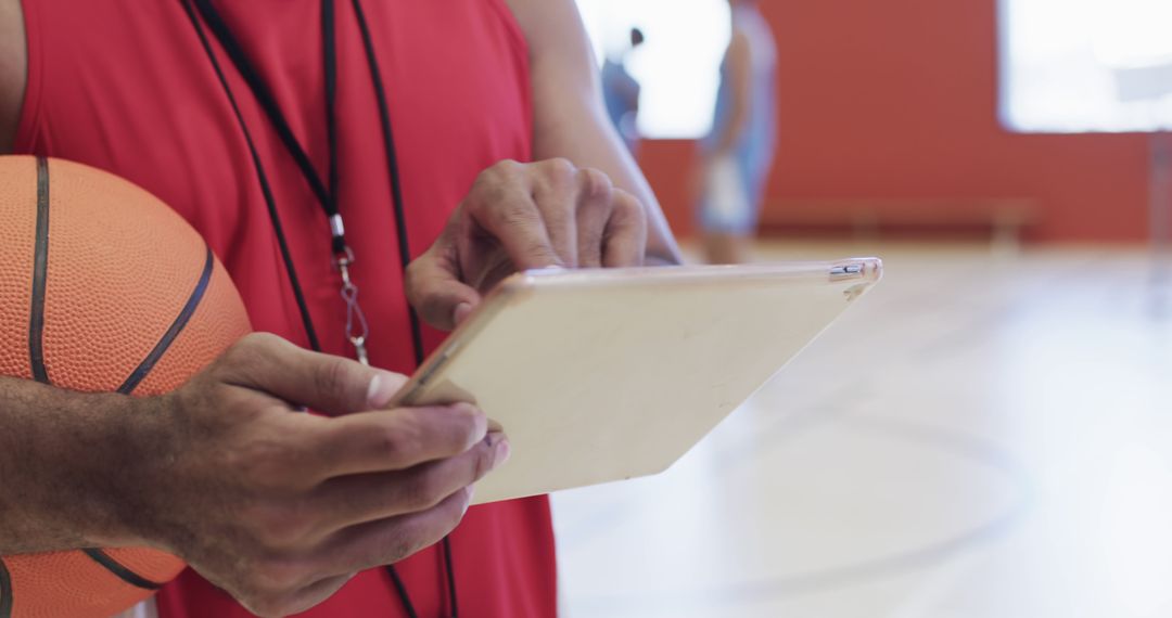 Basketball Coach Analyzing Strategies on Tablet