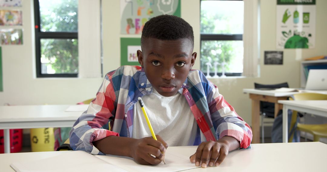 Focused African American Boy Writing in Classroom Environment