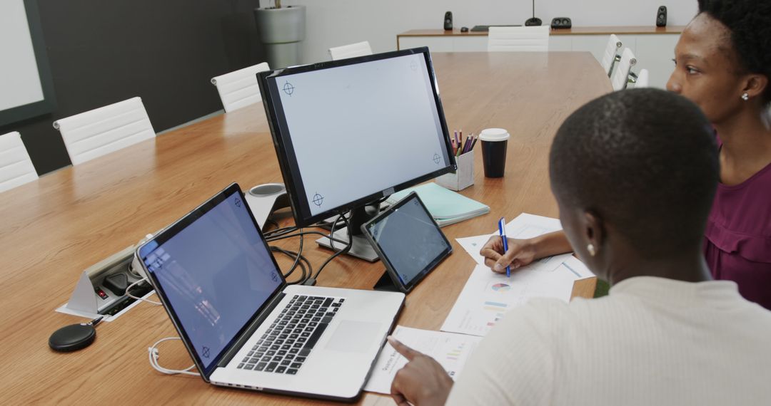 Two Professionals Analyzing Data on Multiple Screens in Modern Meeting Room - Free Images, Stock Photos and Pictures on Pikwizard.com