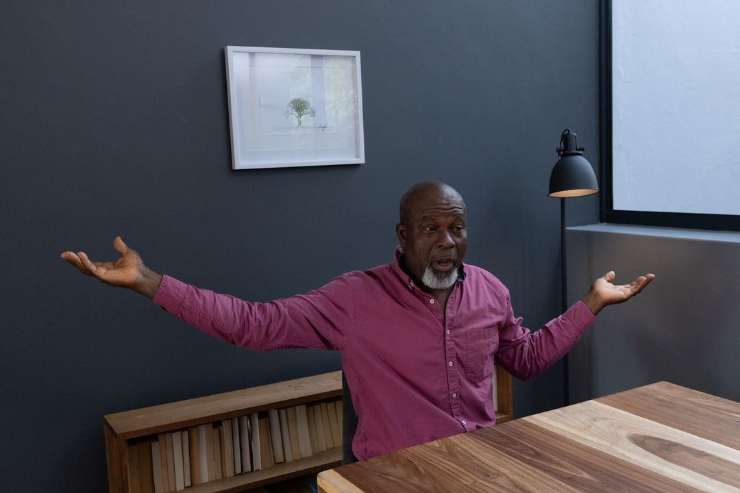 Senior Man Gesturing During Meeting in Contemporary Office Space
