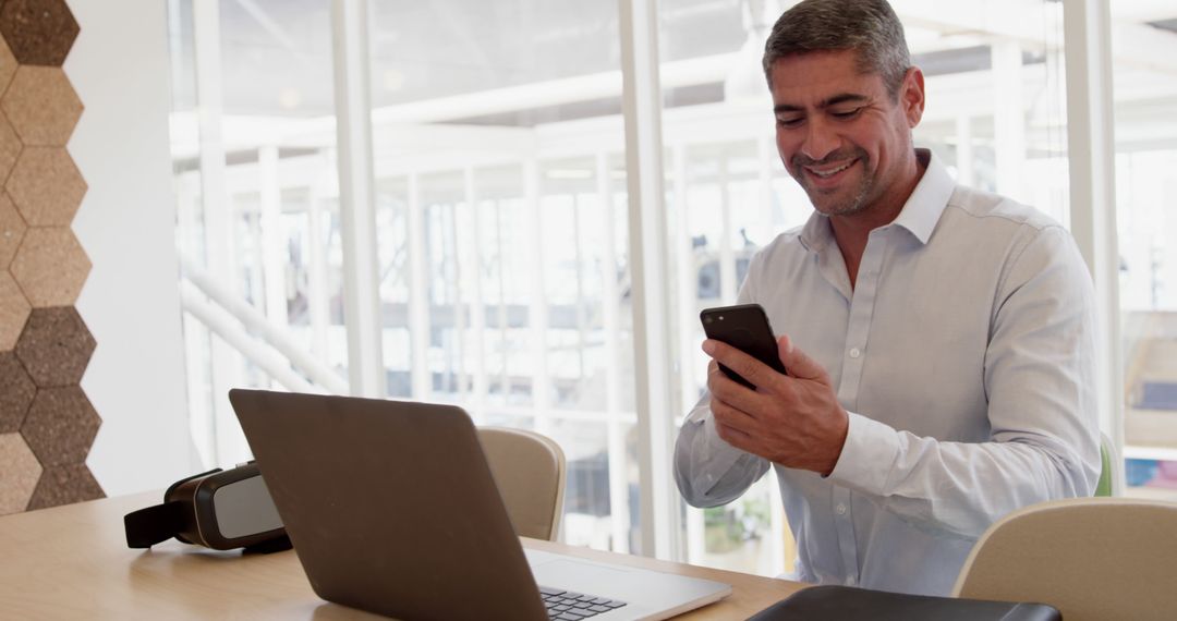 Smiling Businessman Using Smartphone at Modern Office Desk - Free Images, Stock Photos and Pictures on Pikwizard.com