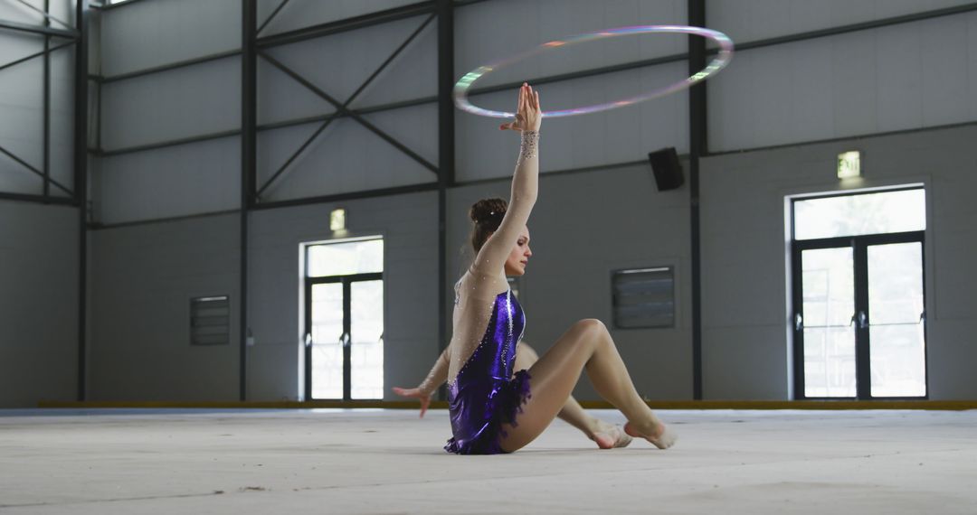 Young Gymnast Performing with Hula Hoop at Indoor Arena - Free Images, Stock Photos and Pictures on Pikwizard.com