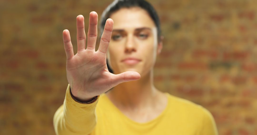 Young Woman with Hand Stretched Forward Making Stop Gesture - Free Images, Stock Photos and Pictures on Pikwizard.com