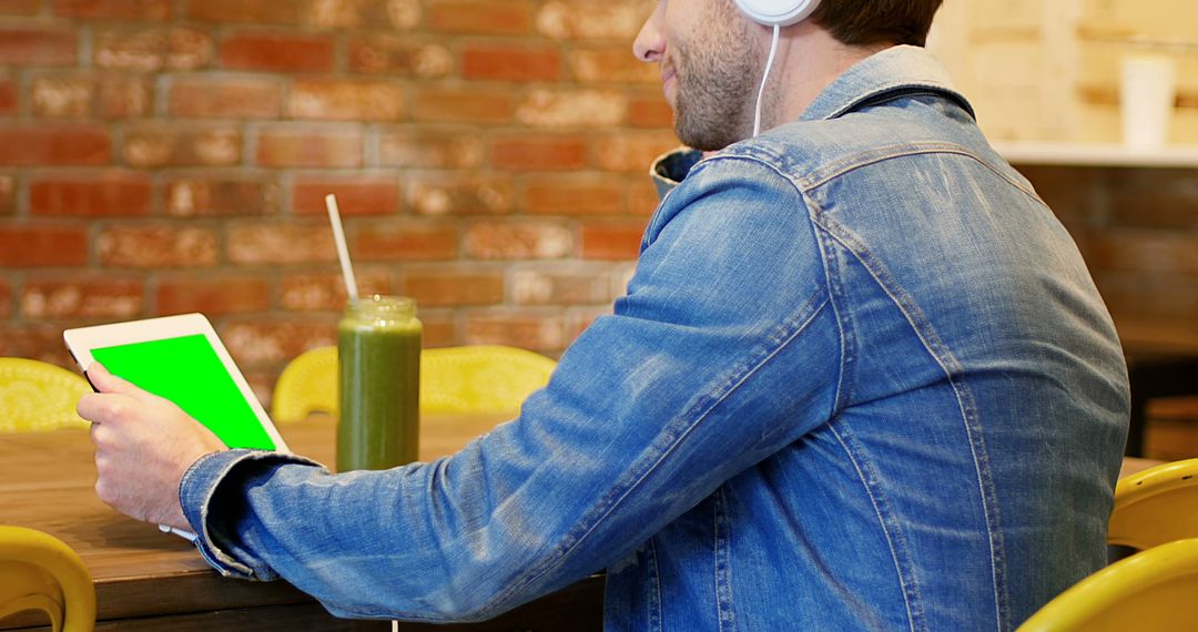 Man Using Tablet in Cafe with Green Smoothie - Free Images, Stock Photos and Pictures on Pikwizard.com