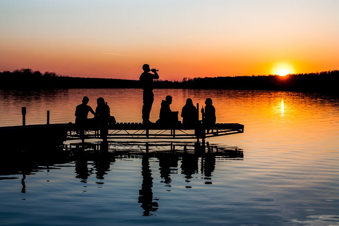 People Relaxing on Lakeside Pier at Sunset - Free Images, Stock Photos and Pictures on Pikwizard.com