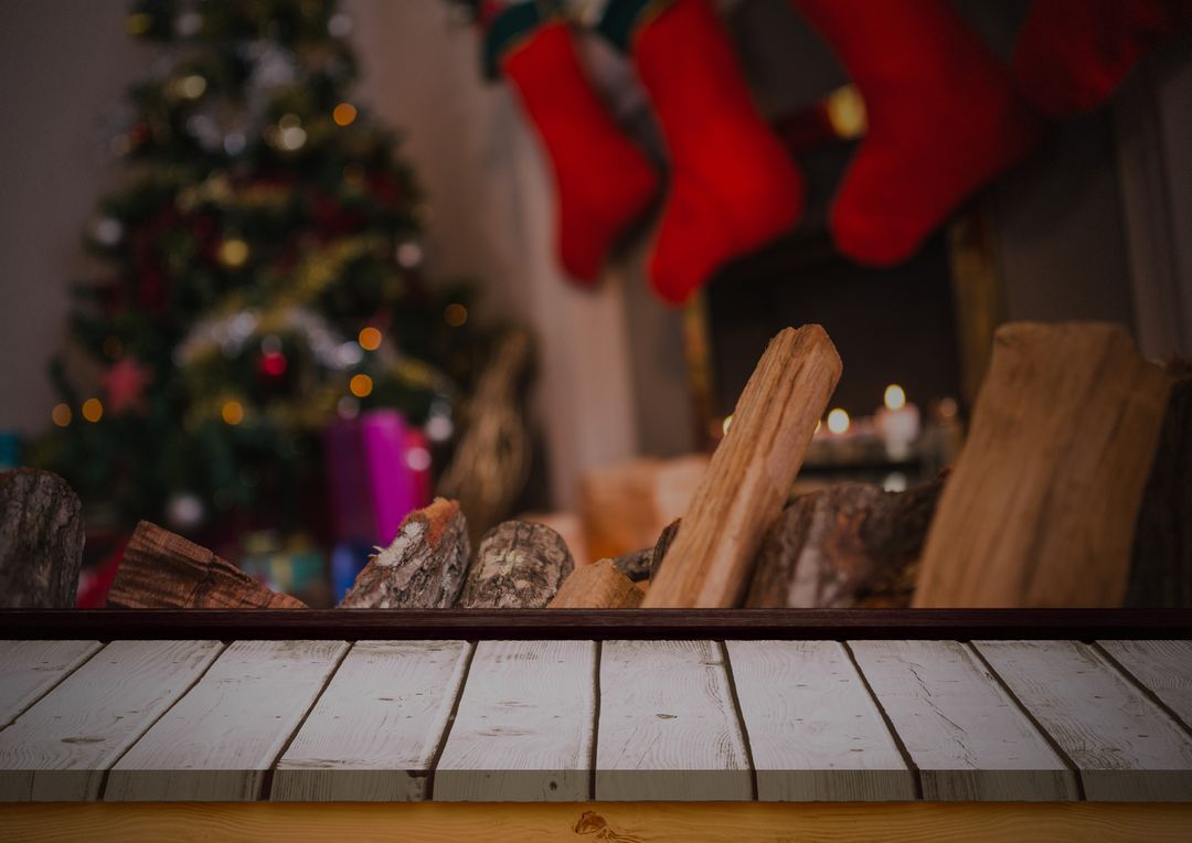 Firewood on Wooden Table with Blurred Christmas Tree and Stockings in Background - Free Images, Stock Photos and Pictures on Pikwizard.com