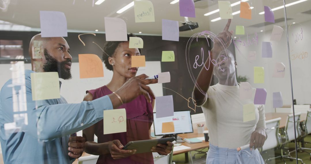 Multiracial Team Brainstorming with Sticky Notes on Glass Wall - Free Images, Stock Photos and Pictures on Pikwizard.com