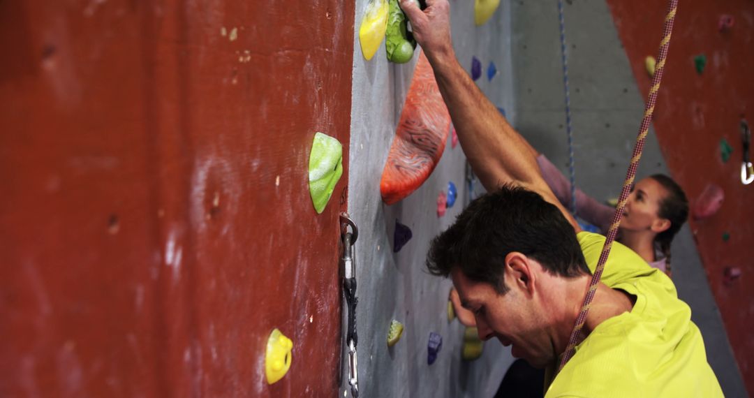 Man and Woman Climbing Indoor Rock Wall Together - Free Images, Stock Photos and Pictures on Pikwizard.com